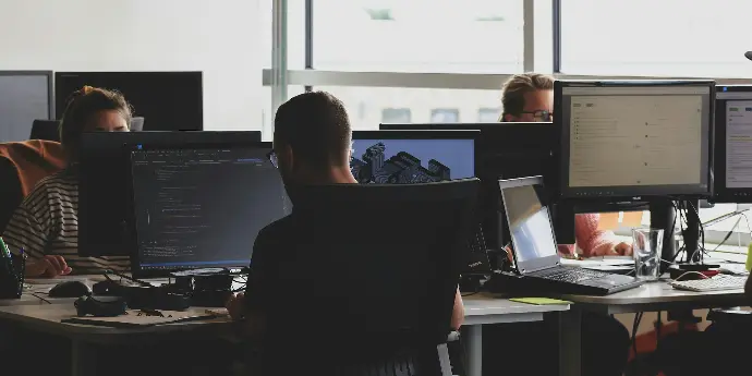 people sitting on chair in front of computer monitor