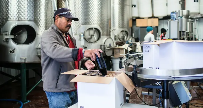 man in gray jacket and blue denim jeans holding white paper