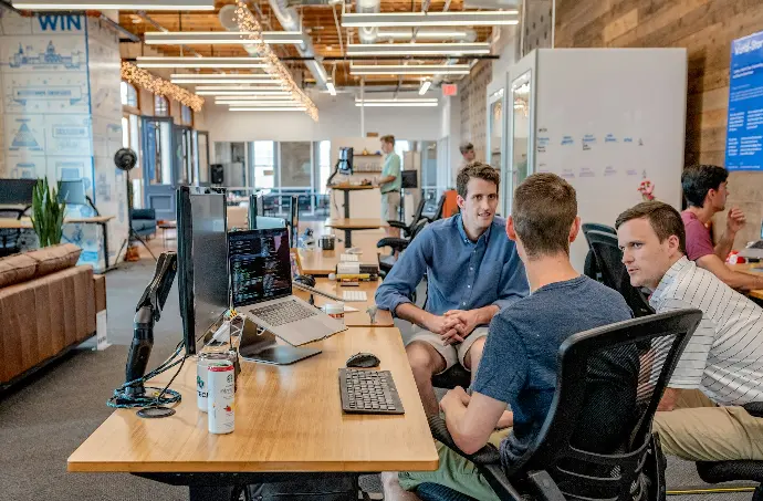 three men sitting on chair beside tables